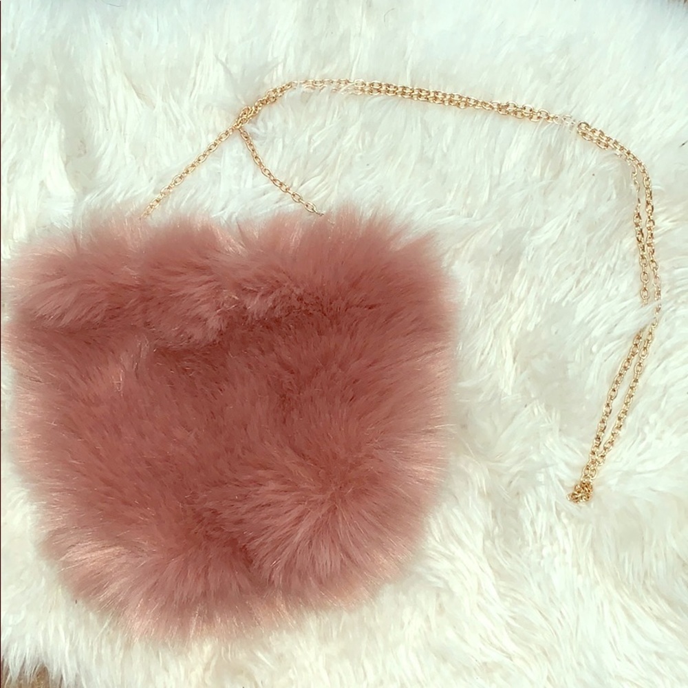 A soft rosy colored handbag with a gold chain